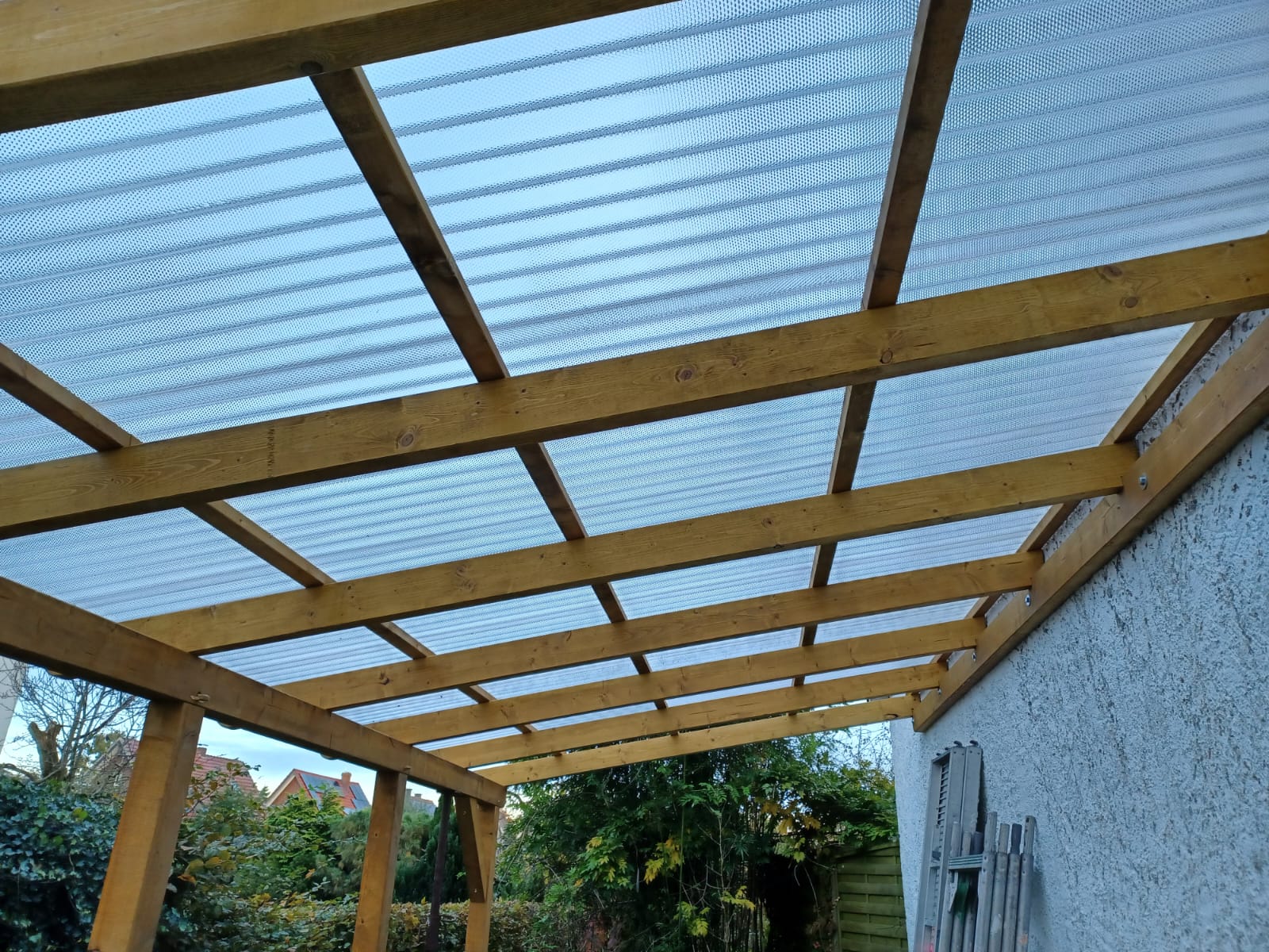 Blick unter die fertige Holzkonstruktion einer Terrassenüberdachung
